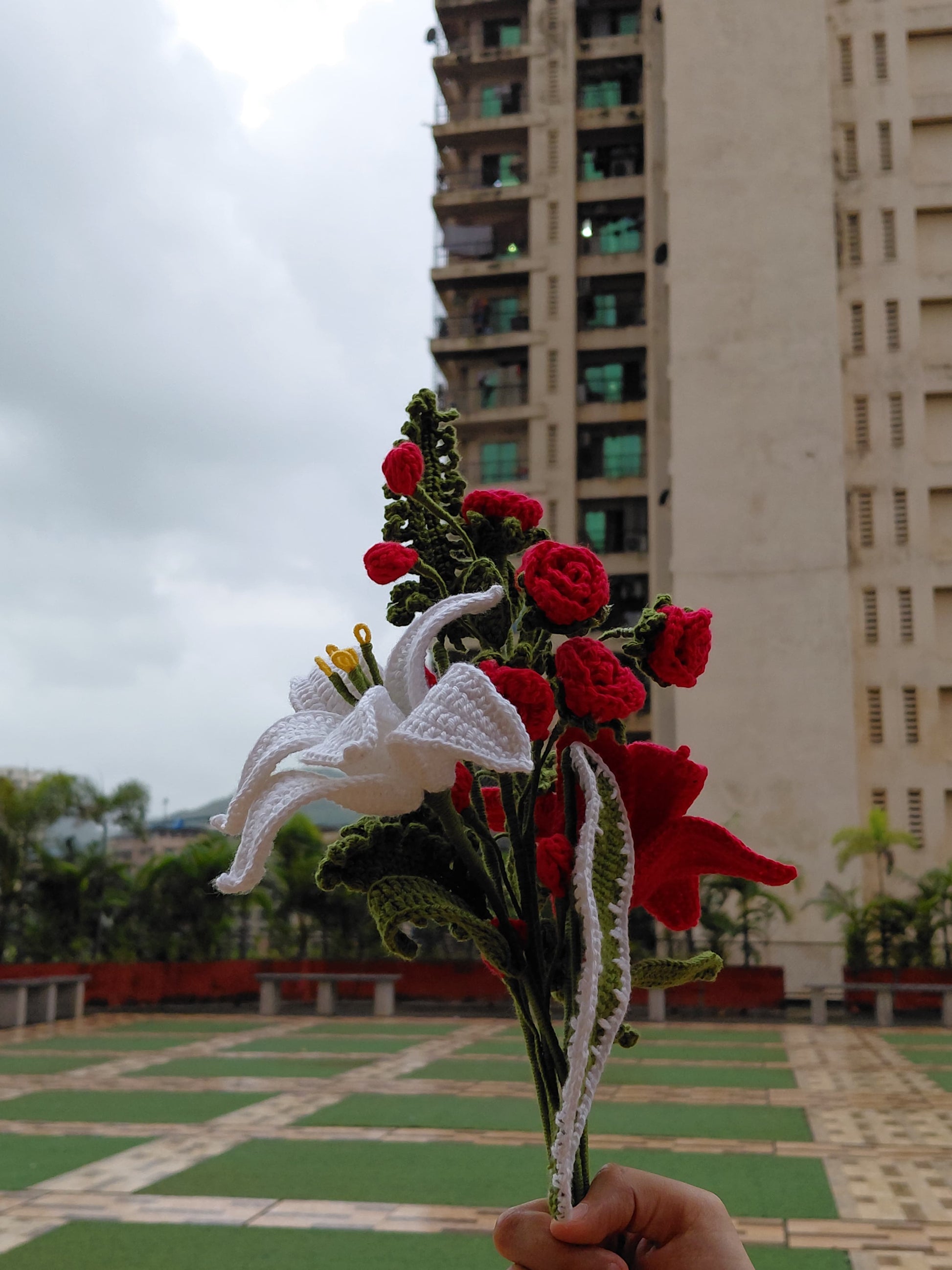 Beautiful handmade crochet floral bouquet featuring roses, lilies, and greenery, perfect for unique gifts and décor.