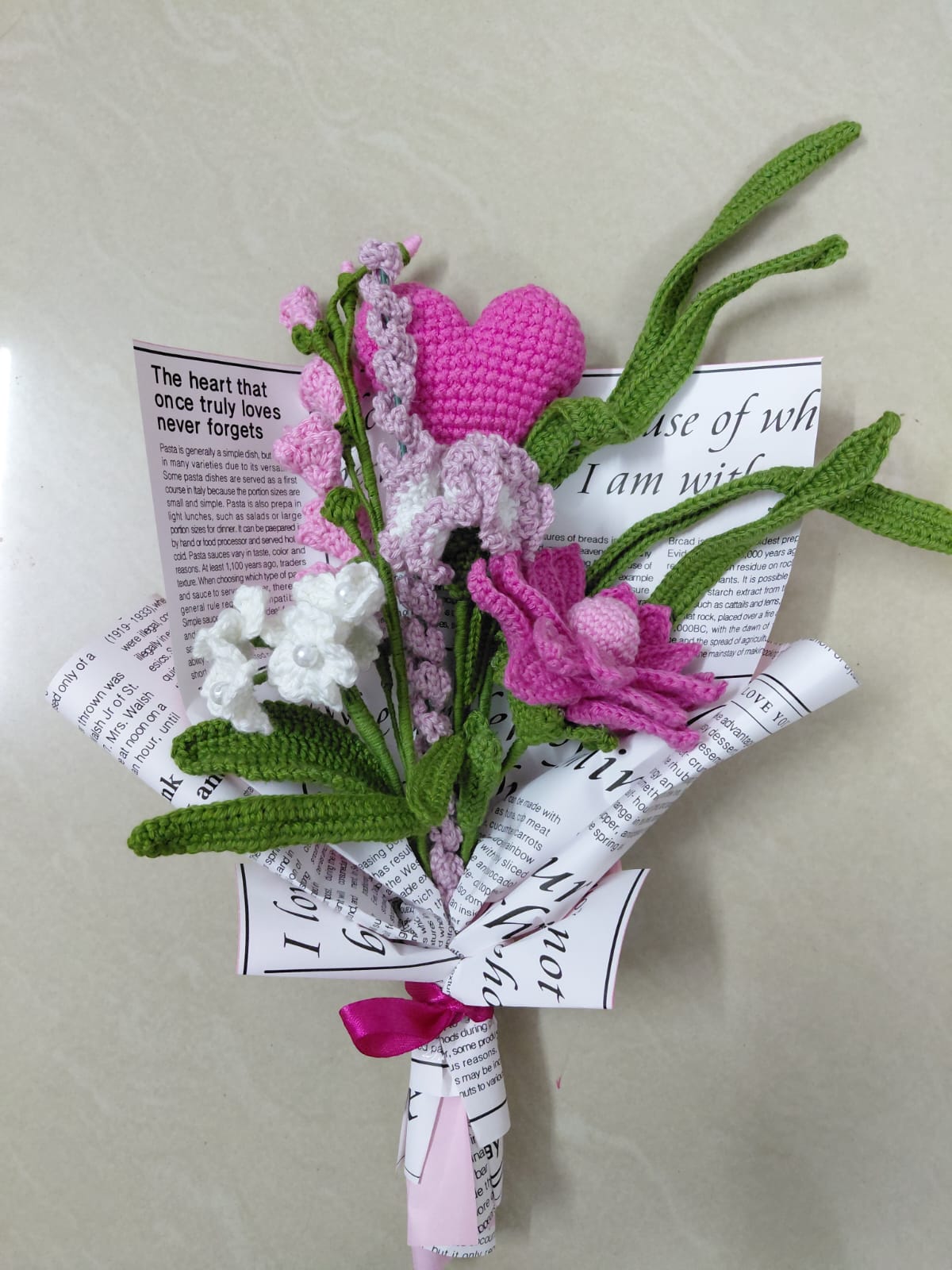 Crochet bouquet featuring pink heart, lotus flower, and white blossoms, handcrafted sustainable gift for weddings and anniversaries.