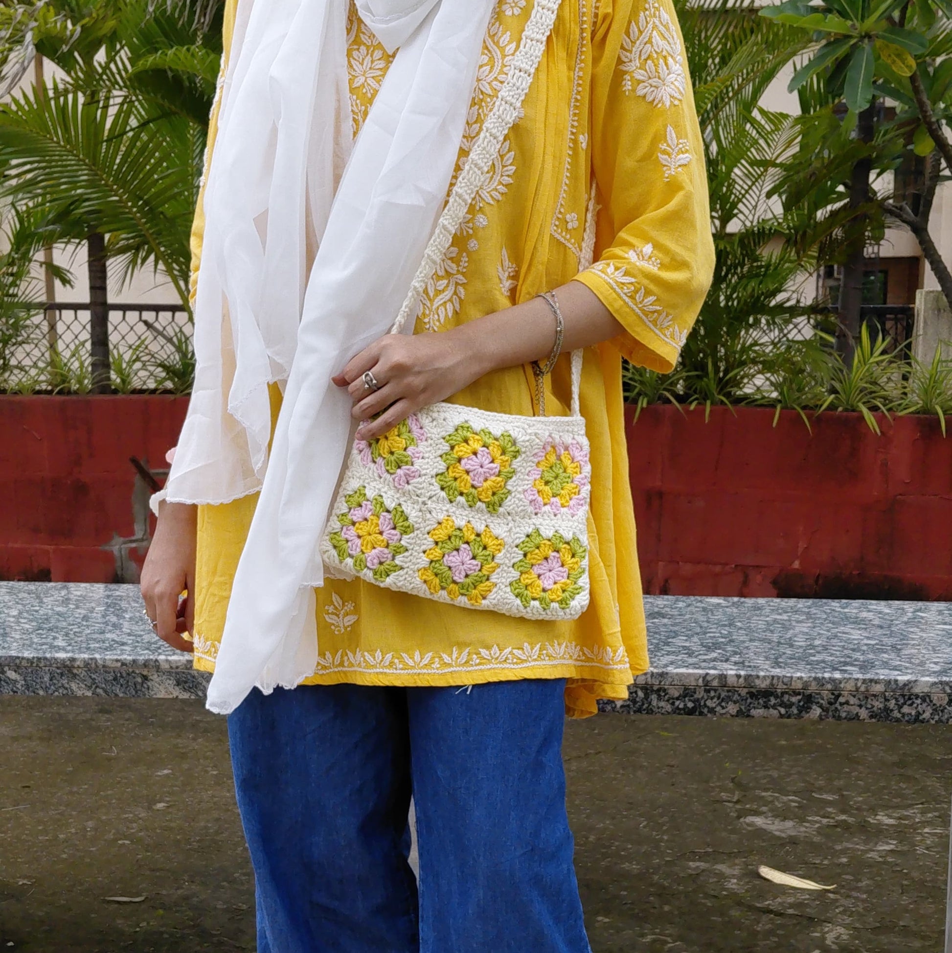 Handcrafted crochet shoulder bag with green, pink, white  and yellow squares, stylish sustainable fashion accessory for women.