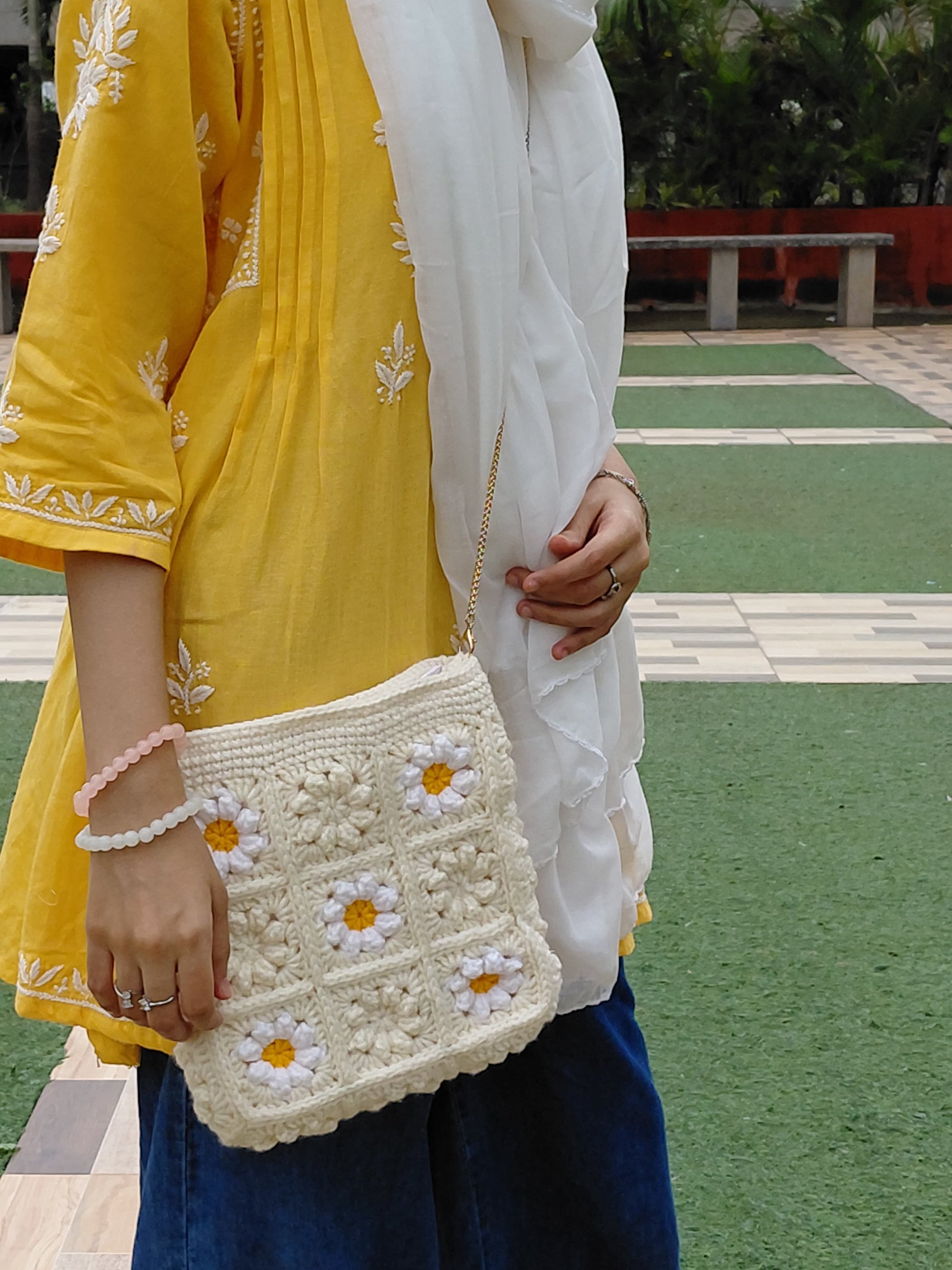 Crochet floral granny square handbag with daisy motifs and golden chain strap, stylish casual shoulder bag for women.