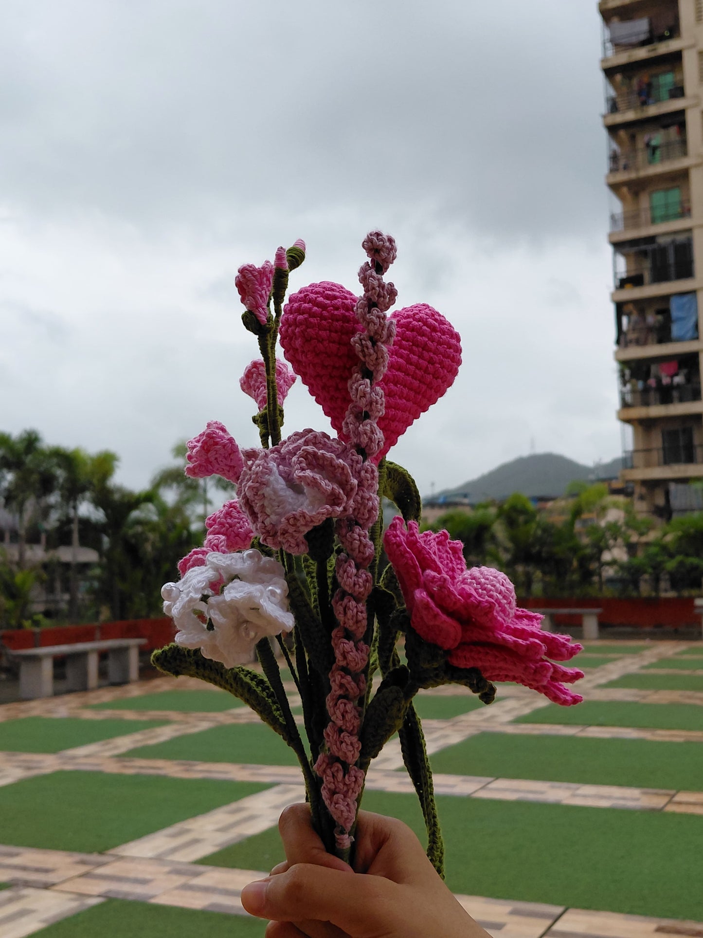 Handcrafted crochet bouquet with pink flowers and heart plushie, unique sustainable alternative to fresh flowers for gifting.
