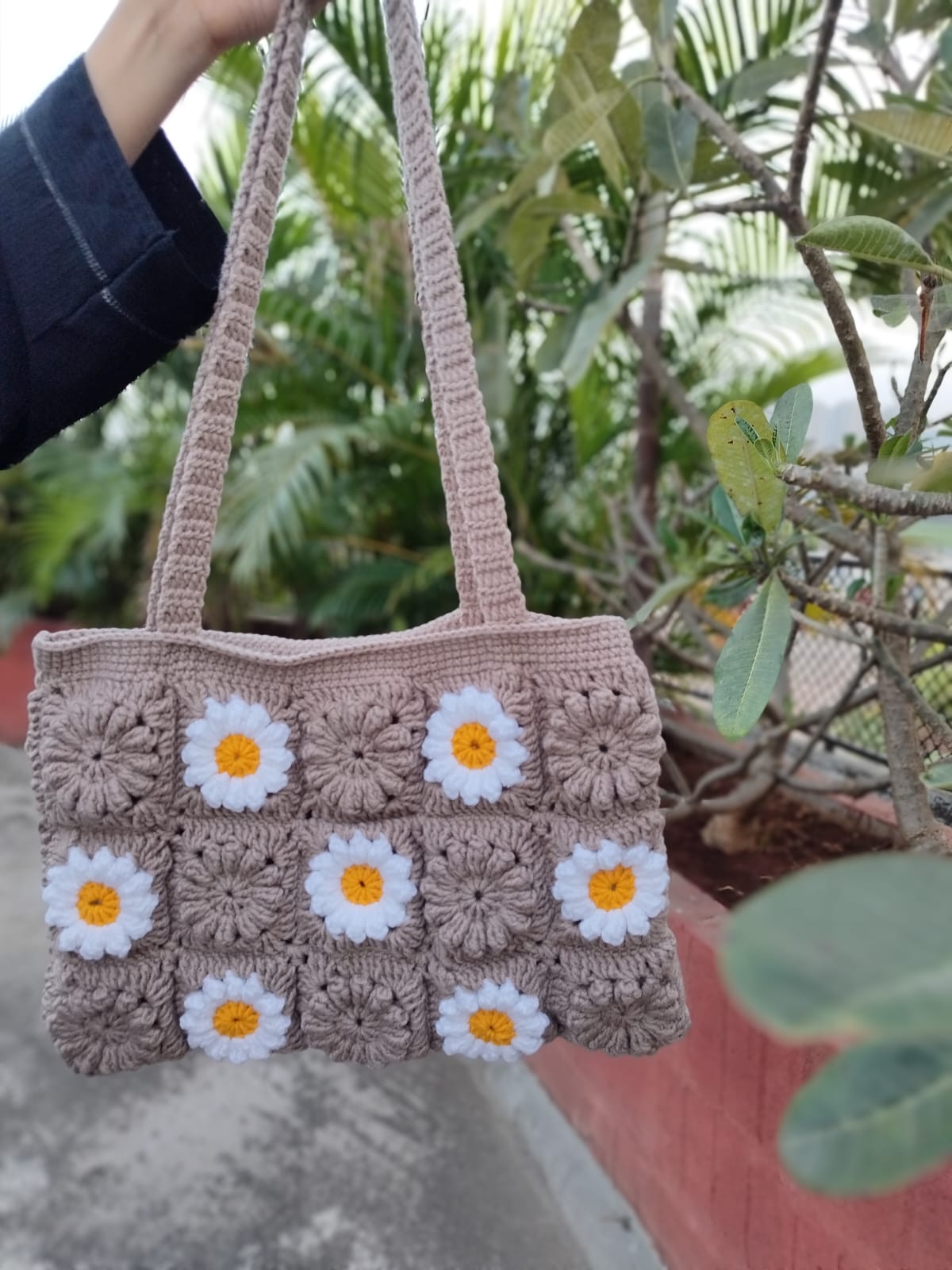 Stylish handmade crochet bag with daisy motifs, perfect boho-chic accessory for Gen Z fashion lovers.