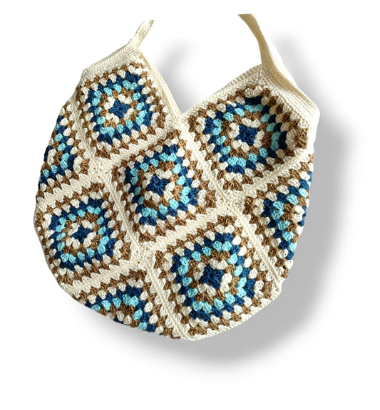 Crochet shoulder bag with blue, white, and brown granny square pattern, stylish handmade accessory.